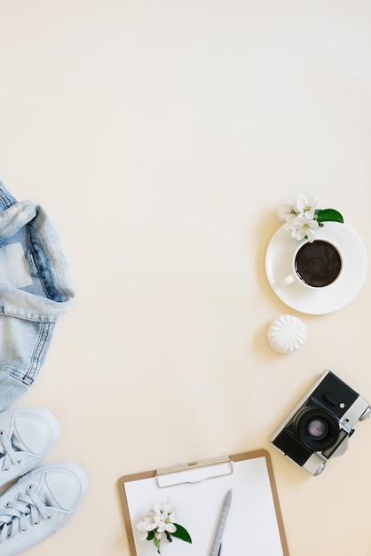 Vacation planning concept still life Clothes a cup of coffee a camera and a notepad with a pen