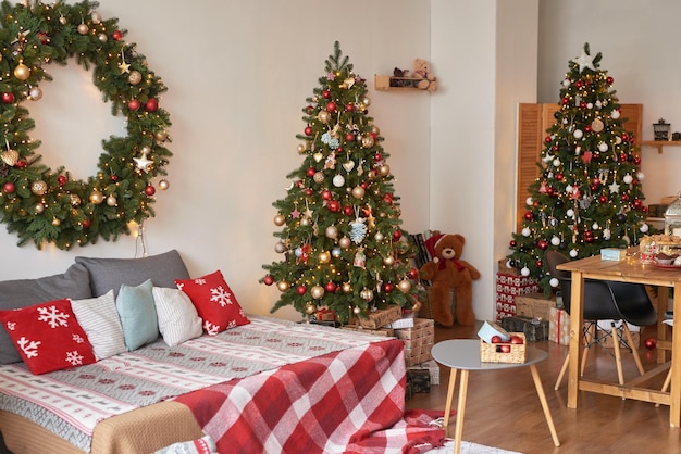 Vacation Rentals Interior apartment Christmas bedroom Bed against background of Christmas tree and wreath New Year's Eve celebration at home