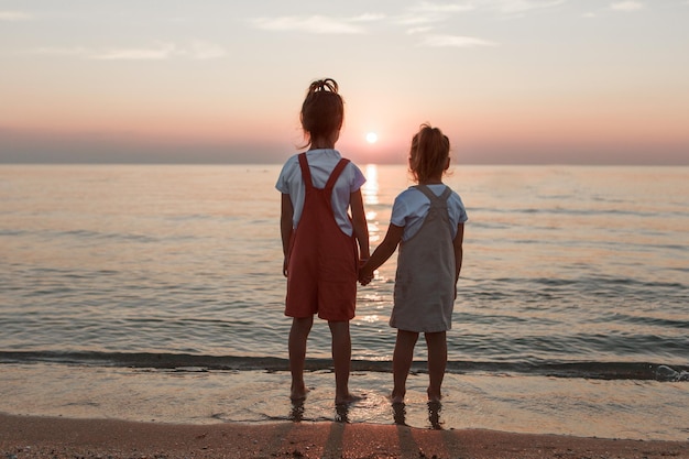 Vacation at sea a family walks along the beach children holding hands