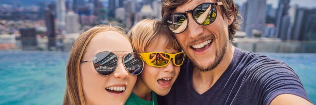 Vacation and technology happy family with kid taking selfie together near swimming pool with