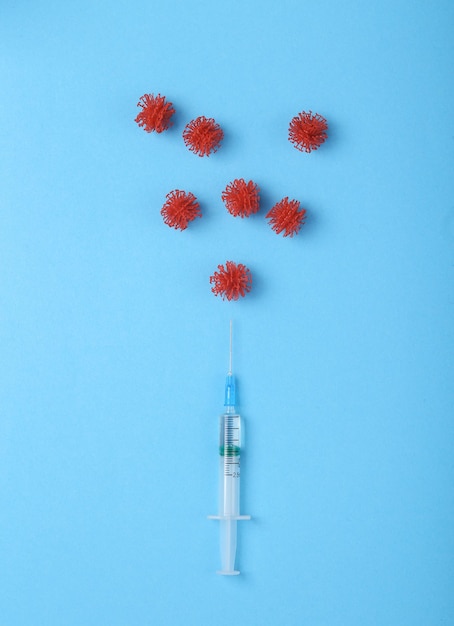 Photo vaccination against covid 19 syringe with virus molecules on a blue background