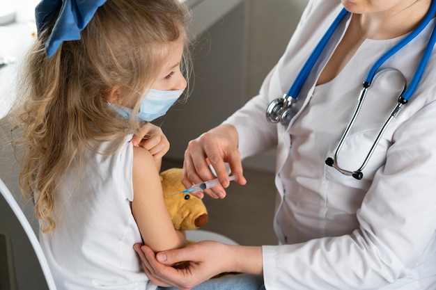 Vaccination of children a little girl at a doctors appointment an injection in the arm the conce