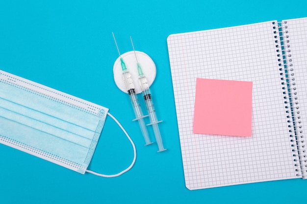 Vaccination or revaccination concept  a medical syringe on blue table