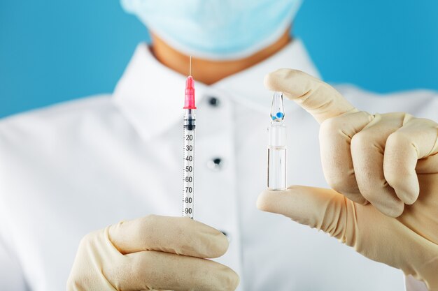 Vaccine ampoule in the hands of a physician researcher