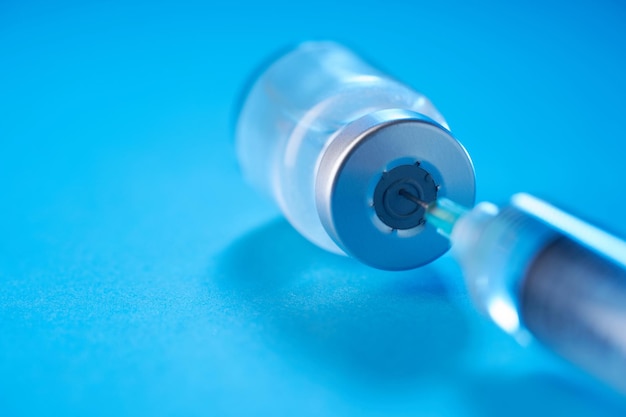 Vaccine bottle on the blue background