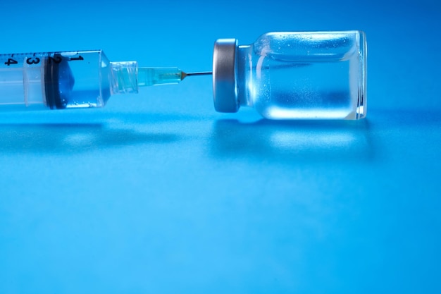 Vaccine bottle on the blue background