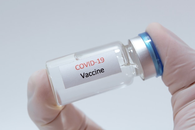 Vaccine COVID-19 (Coronavirus) glass bottle in medical doctor hand