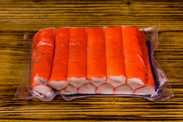 Vacuum pack of crab sticks on a wooden table