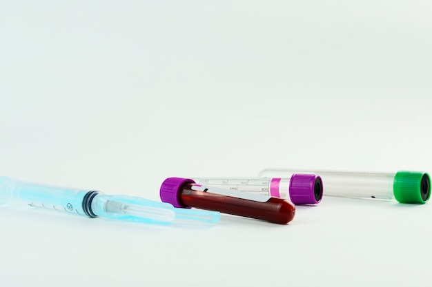 vacuum tubes for collection and blood samples and a syringe isolated on background selective focus