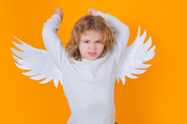 Photo valentine angel little cupid child kid angel with angels wings isolated on yellow studio background valentines day gift card