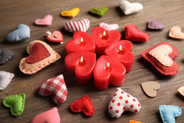 Valentine concept Composition of candles and hearts on wooden table background