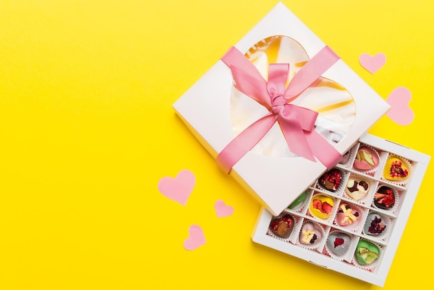 Valentine day composition sweet candy with gift boxes with bow and red felt hearts photo template background Top View with copy space