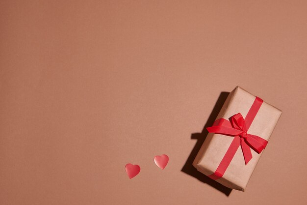 Valentine day composition with copy space.Present or gift box  with ribbon bow and red hearts.