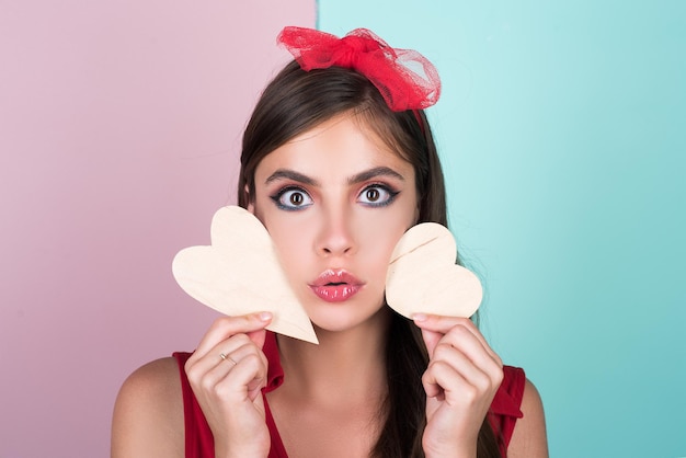 Valentine day love beautiful young woman brunette girl with hearts isolated on color wall girl with ...