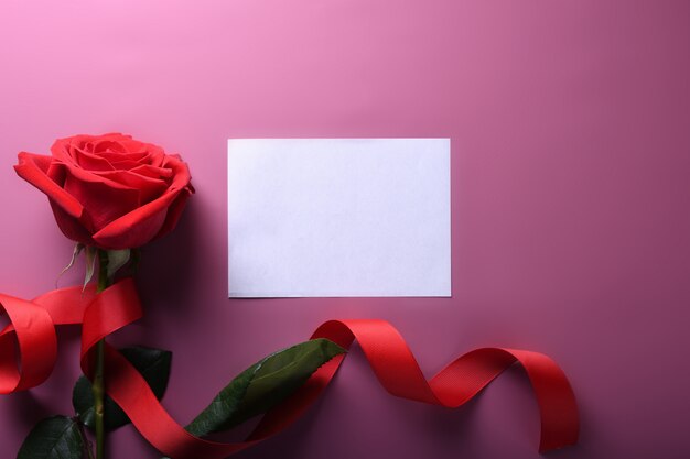 Photo valentine's day background greeting card love symbols , red decoration with roses on pink background. top view with copy space and text.flat lay