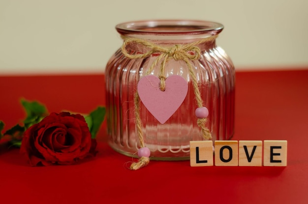 Valentine's day background. Red rose in a glass vase on a pink background.