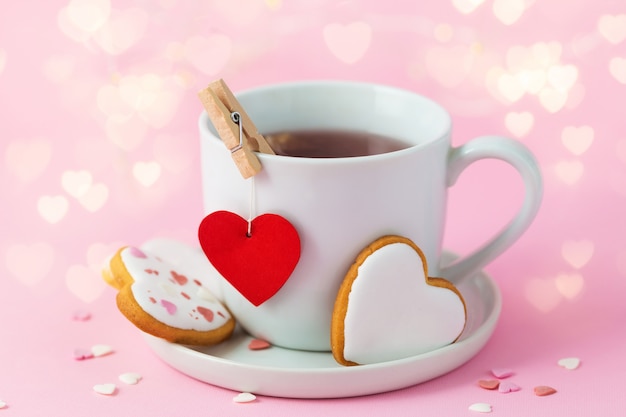 Valentine's day background with bokeh light.  Cup of tea with red heart and cookies