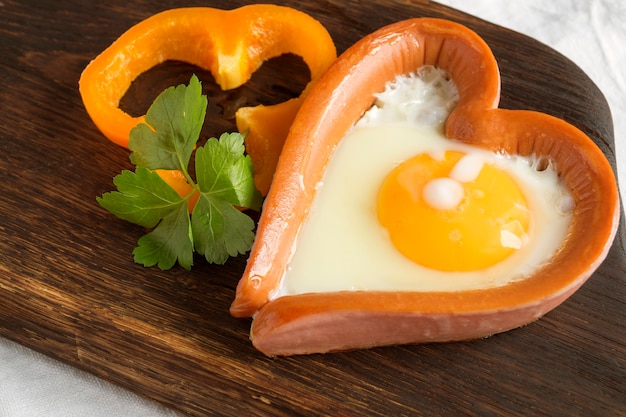 Valentine's day breakfast. sausage with scrambled egg in the shape of a heart.