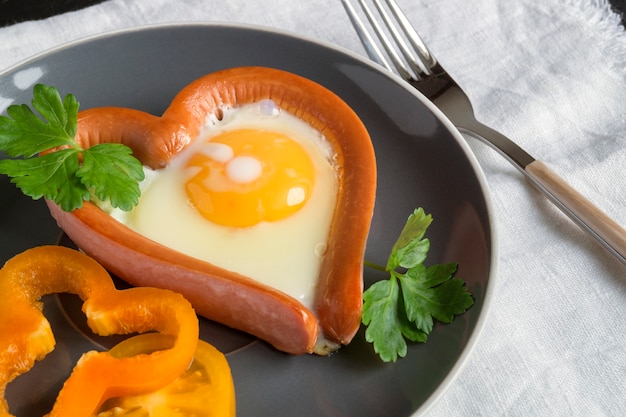 Valentine's day breakfast. sausage with scrambled egg in the shape of a heart.