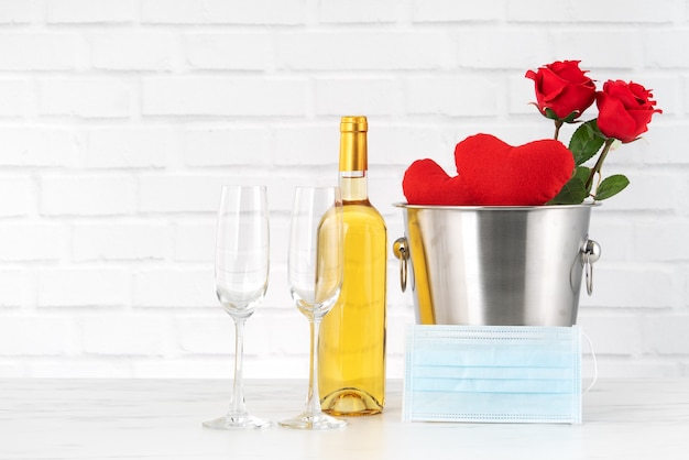 Valentine's Day celebration with wine, bouquet and face mask protection concept during this hard time.