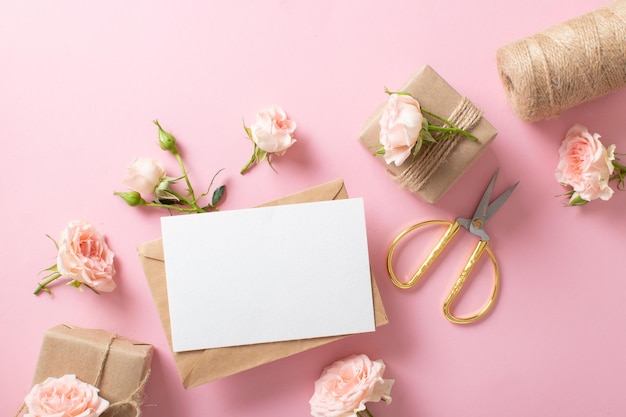 A Valentine's Day composition of ecopackaged gifts a kraft envelope and fresh flowers on a light pink background Vintage banner