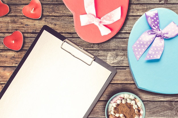 Valentine's Day composition with clipboard, present and candles