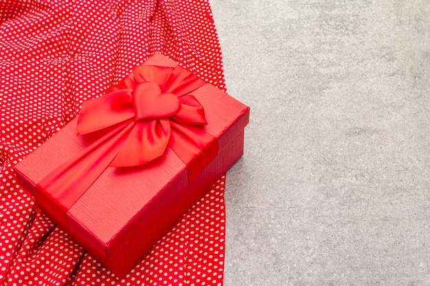 Valentine's Day composition with red gift box and dotted cloth