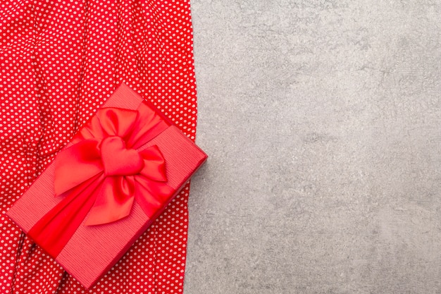 Valentine's Day composition with red gift box and dotted cloth