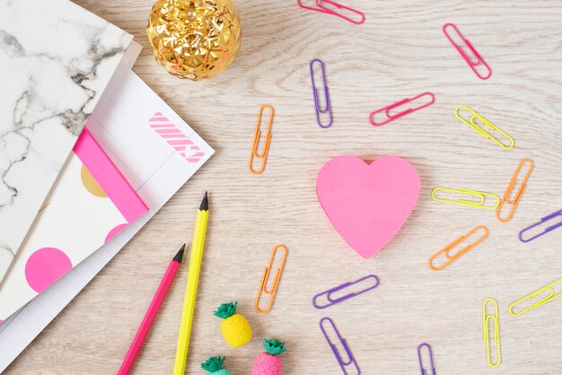 Valentine's Day concept. Freelance fashion femininity workspace in flat lay style with pink paper hearts, marble folder, notebook, pink neon stationery on gray wooden 