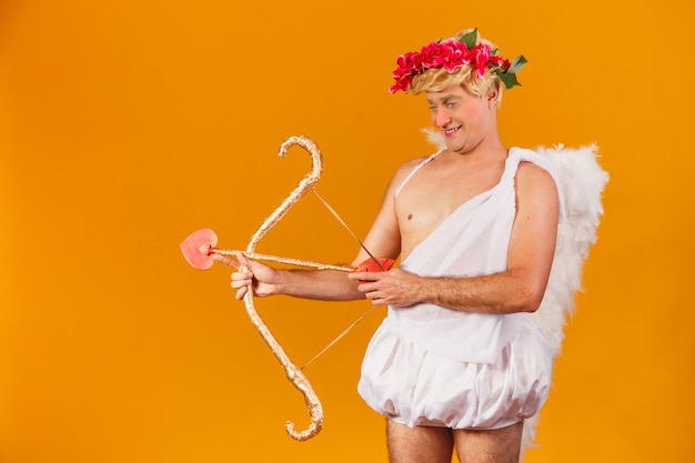 Valentine's day concept. Portrait of the God of love - Cupid with bow and arrow.