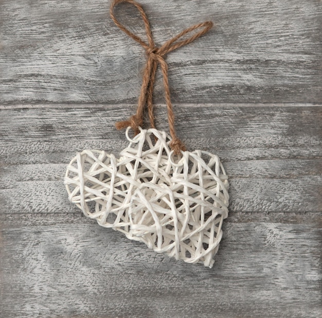 Valentine's day concept two white heart shapes sacred thread on gray wooden background Greeting card