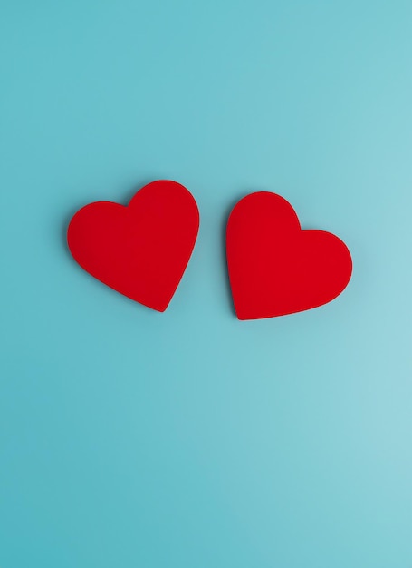 Photo valentine's day concept with two red hearts on light blue background top view