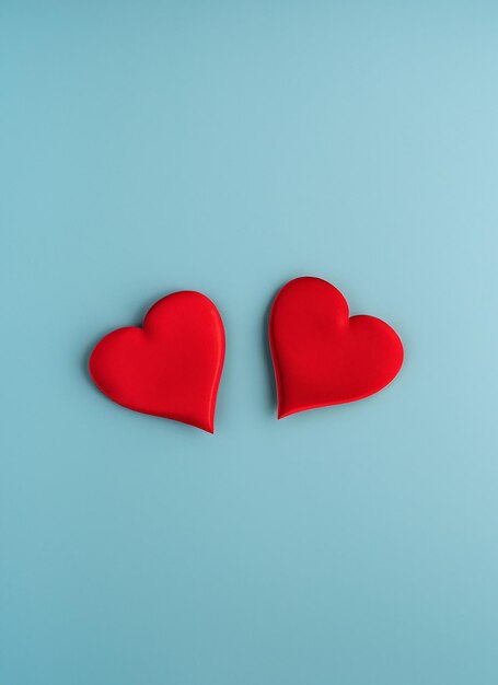 Photo valentine's day concept with two red hearts on light blue background top view