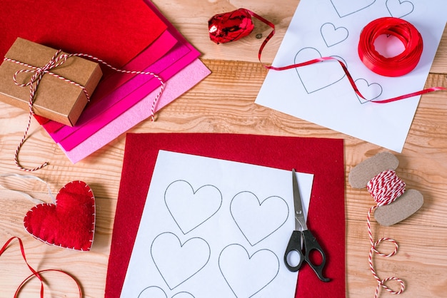 Valentine's day crafting, hearts and decorations made of felt on wooden table