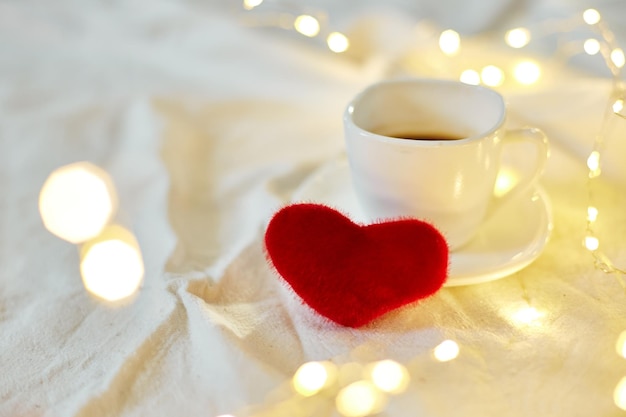 Valentine's Day Cup of coffee in bed with a red hearts and lights