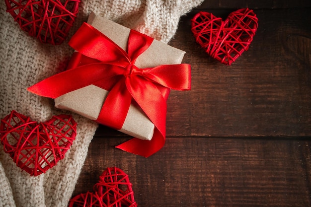 Valentine's Day gift in a box with a red ribbon on a brown background