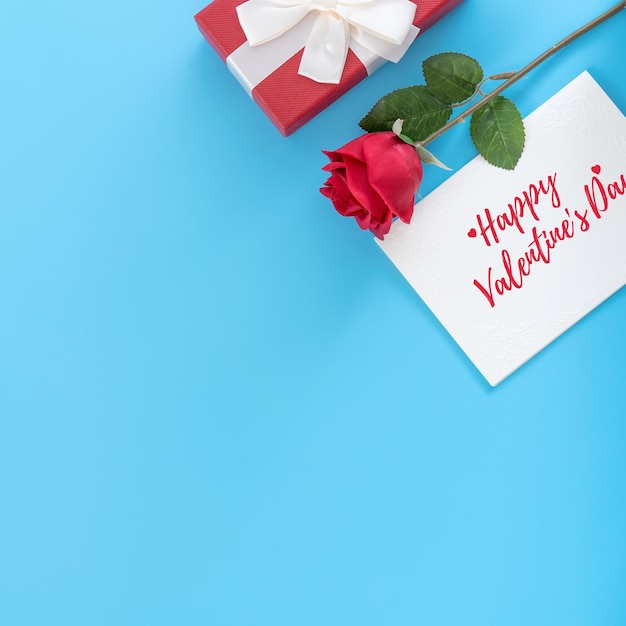 Valentine's Day gift card with greeting word design concept woman sending gift on vibrant blue background top view overhead