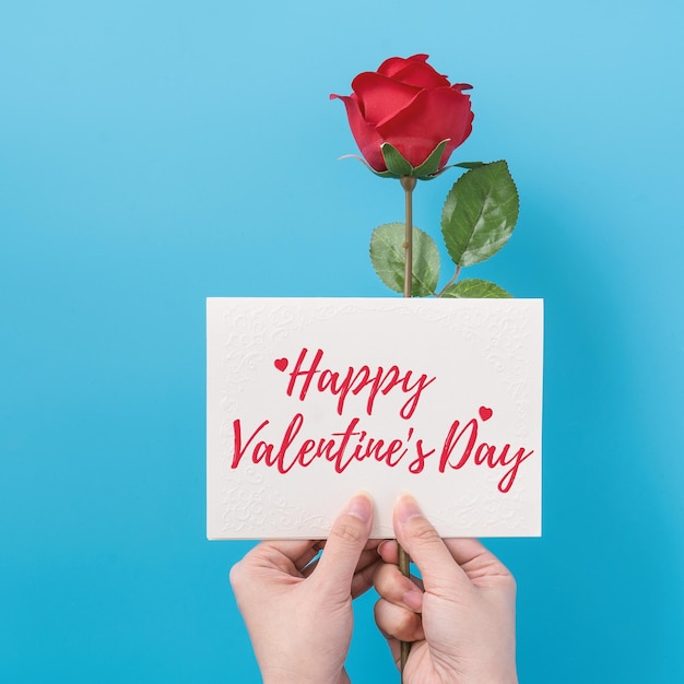 Valentine's Day gift card with greeting word design concept woman sending gift on vibrant blue background top view overhead