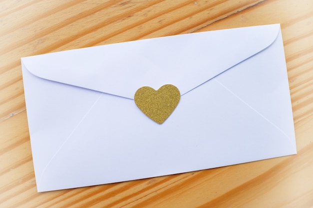 Valentine's day love letter envelope with hearts on wooden background. copy space.