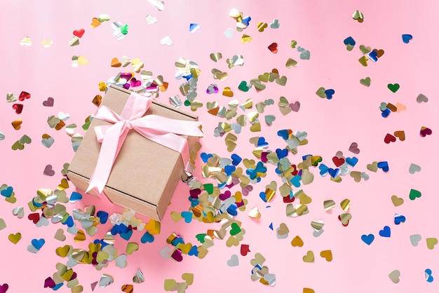 Valentine's day pink table with pink gift boxes and heart shape confetti