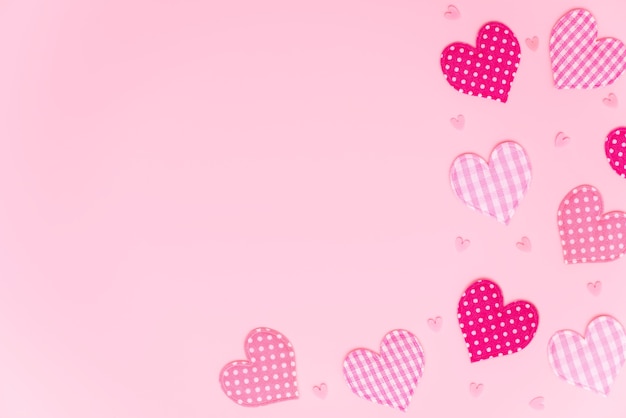 Valentine's or Mother's Day background. Fabric hearts with different patterns on pastel pink with