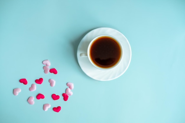 Valentines blue background concept with coffee cup and hearts