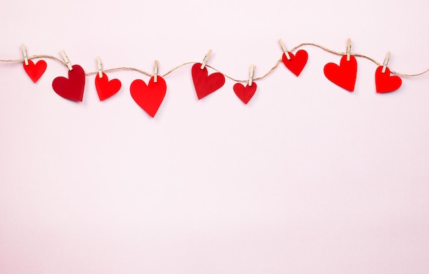 Valentines on clothespins on a pink background