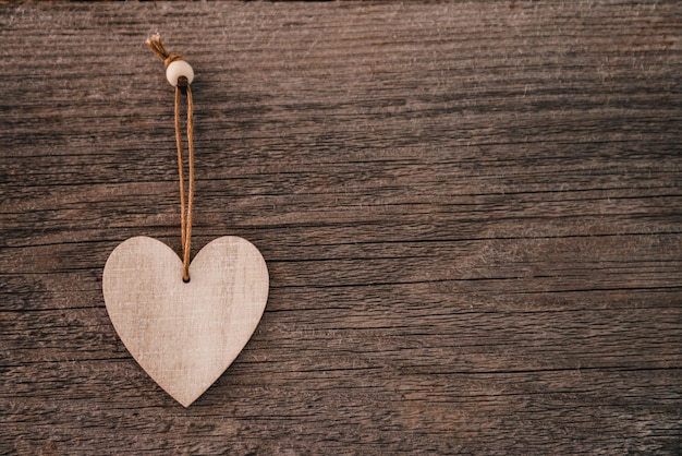 Valentines day background brown natural boards in grunge style with one wooden decorative hearts top...