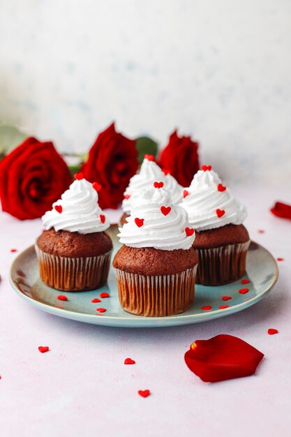 Valentines day background, chocolate cupcakes with heart shaped candies,top view