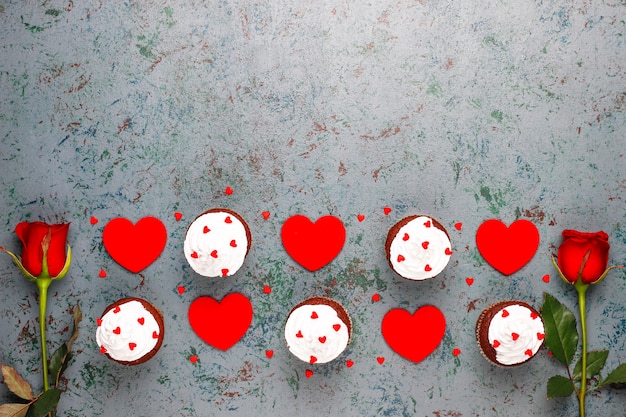 Valentines day background, chocolate cupcakes with heart shaped candies,top view