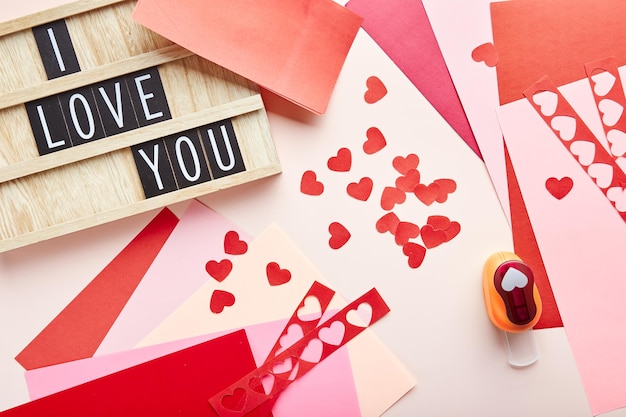 Valentines day background Paper hearts colored paper paper cutter and letterboard wit text