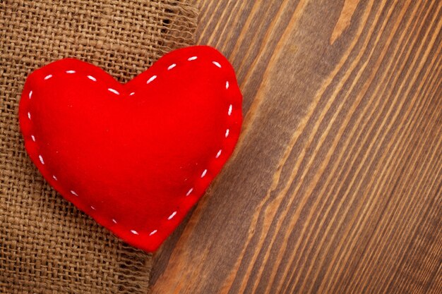 Valentines day background with handmade toy heart over wooden table