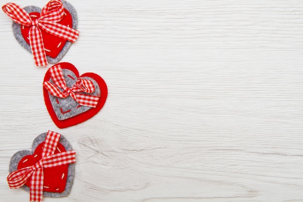 Valentines day background with handmade toy hearts over wooden background