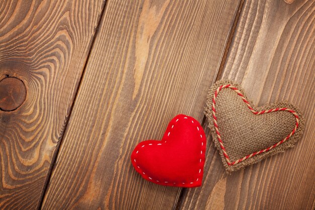 Valentines day background with handmade toy hearts over wooden table